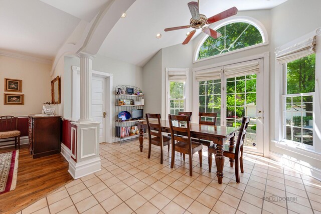 dining area featuring hardwood / wood-style flooring, crown molding, a healthy amount of sunlight, and ornate columns