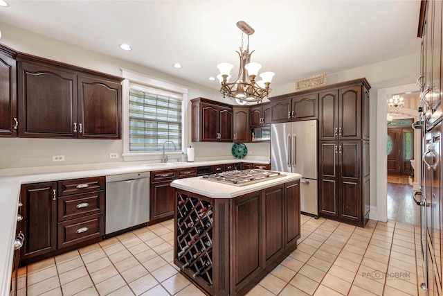 kitchen with a chandelier, dark brown cabinetry, a sink, light countertops, and appliances with stainless steel finishes