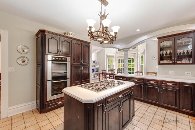 dining room with ornate columns, light tile patterned flooring, lofted ceiling, and ceiling fan with notable chandelier