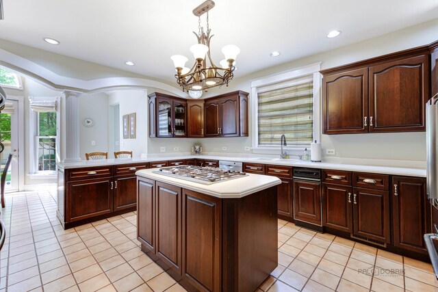 kitchen with sink, hanging light fixtures, dark brown cabinets, stainless steel appliances, and a kitchen island