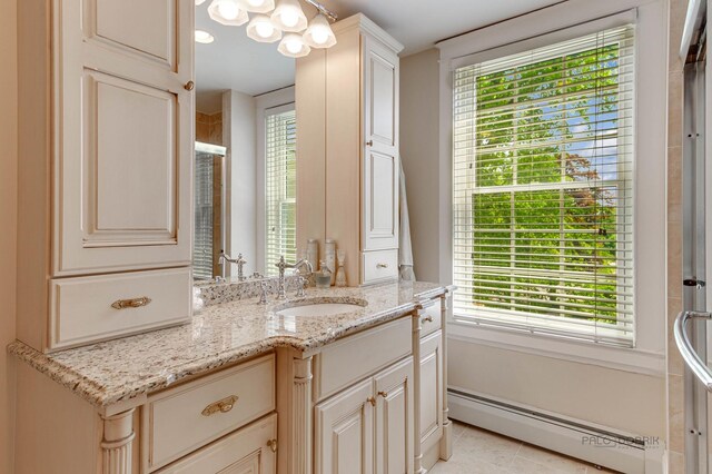 full bath featuring walk in shower, a baseboard radiator, tile patterned flooring, and vanity