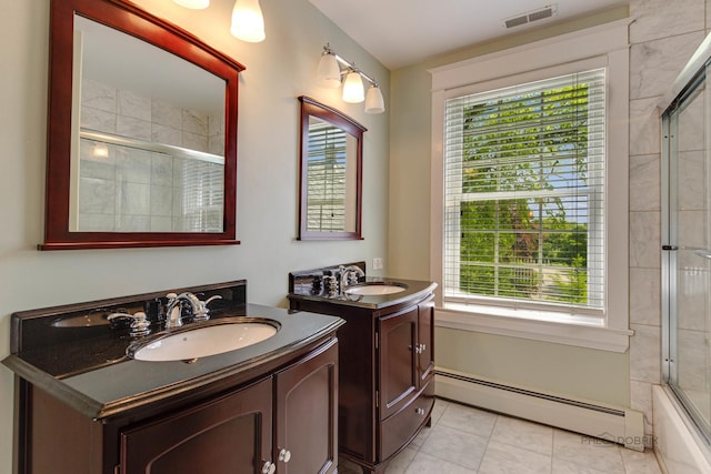 full bathroom with a baseboard radiator, visible vents, two vanities, and a sink