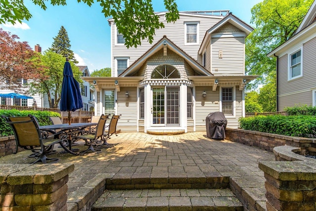 back of property featuring a patio and fence