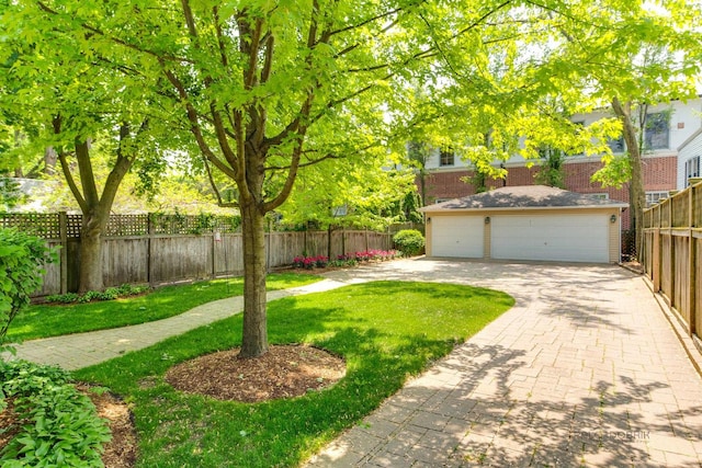 view of yard featuring a garage, an outdoor structure, and fence