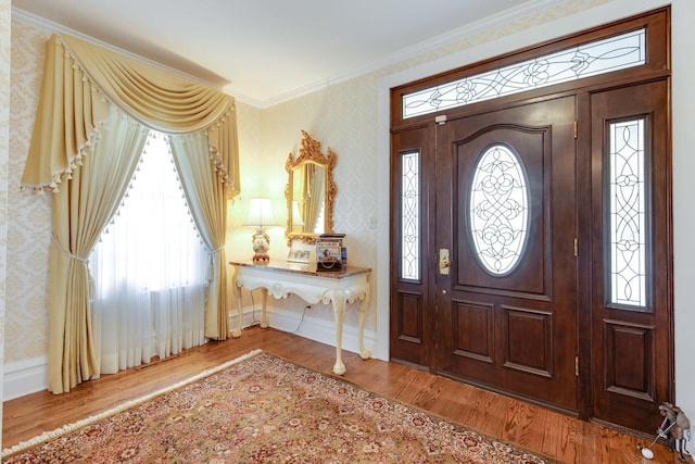 entrance foyer featuring ornamental molding and hardwood / wood-style floors