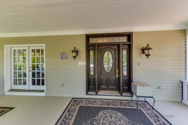 view of exterior entry featuring a porch and french doors