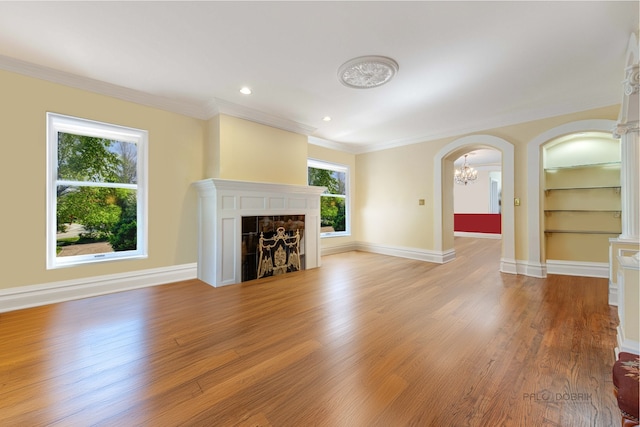 unfurnished living room with light wood-style flooring, a fireplace, built in features, and baseboards