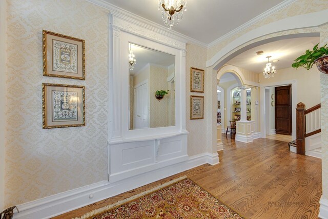 unfurnished living room featuring built in features, ornamental molding, a fireplace, and light hardwood / wood-style flooring