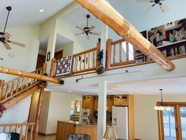 kitchen with a chandelier, white appliances, high vaulted ceiling, and sink