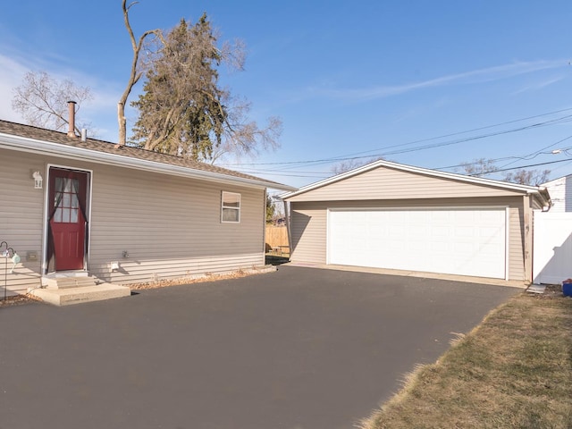 view of front of house with a garage and an outbuilding