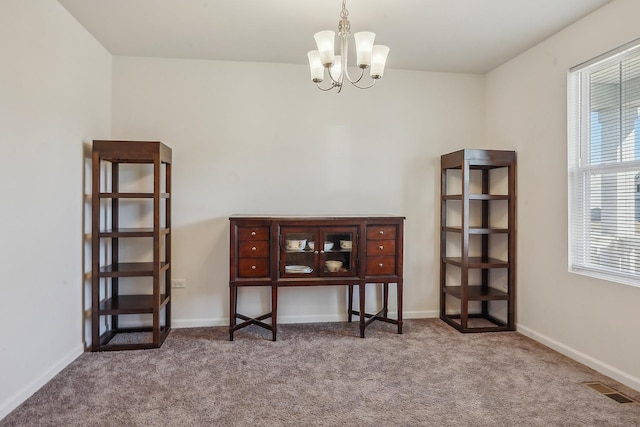 misc room featuring carpet floors and a chandelier