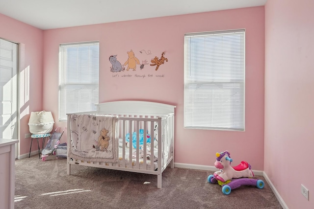 carpeted bedroom with multiple windows and a crib