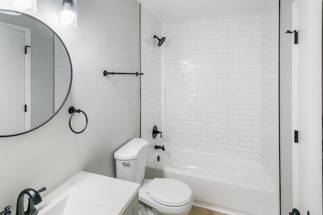 full bathroom with vanity, tiled shower / bath combo, and toilet