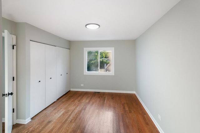 unfurnished bedroom featuring light hardwood / wood-style flooring and a closet