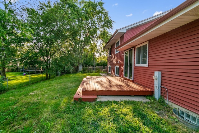 view of yard featuring a trampoline and a wooden deck