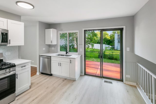 kitchen featuring white cabinets, appliances with stainless steel finishes, and sink