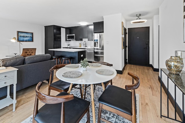 dining area featuring sink and light wood-type flooring