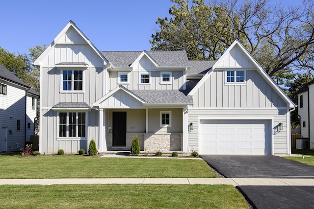 modern inspired farmhouse featuring a front lawn and a garage