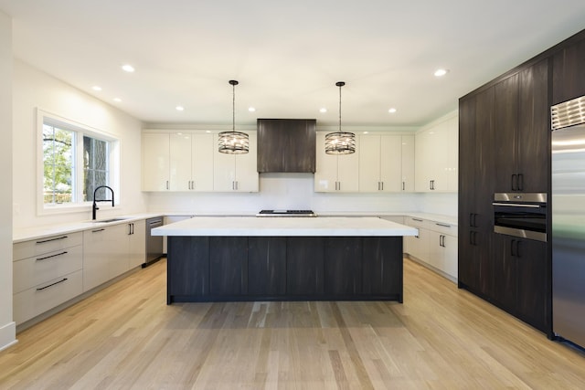 kitchen featuring pendant lighting, a kitchen island, light wood-type flooring, and dark brown cabinetry