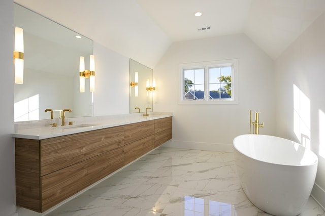 bathroom featuring a washtub, vanity, and lofted ceiling