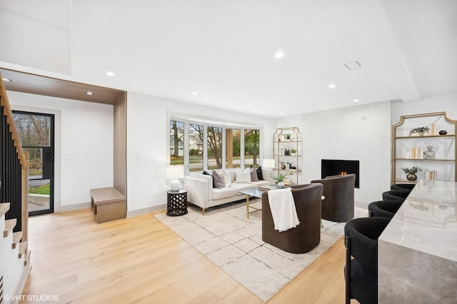 living room featuring a large fireplace and light hardwood / wood-style floors