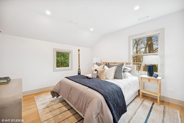 bedroom with light wood-type flooring and vaulted ceiling