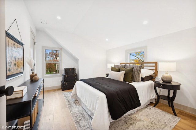 bedroom featuring light hardwood / wood-style floors and lofted ceiling