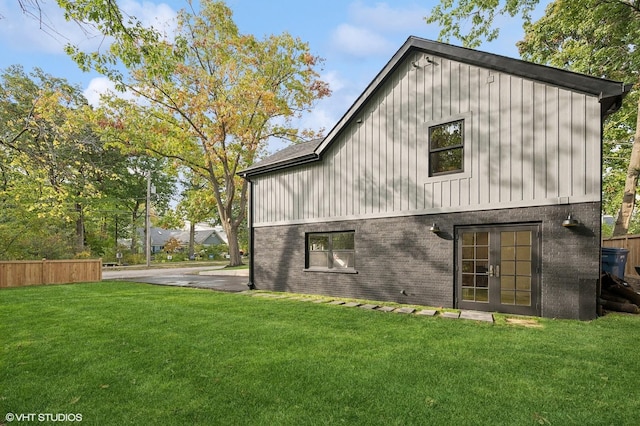 back of house featuring a yard and french doors