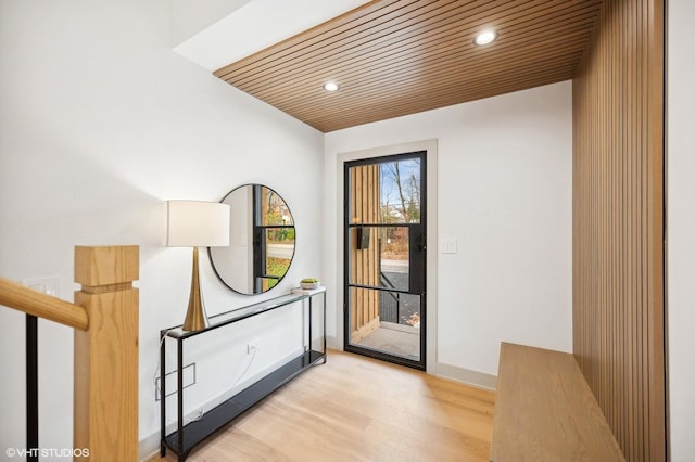 doorway to outside with light hardwood / wood-style flooring and wood ceiling