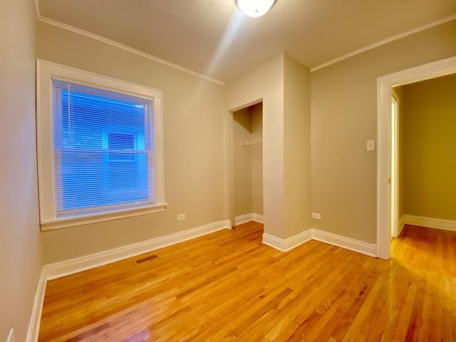 unfurnished room featuring ornamental molding and light hardwood / wood-style floors