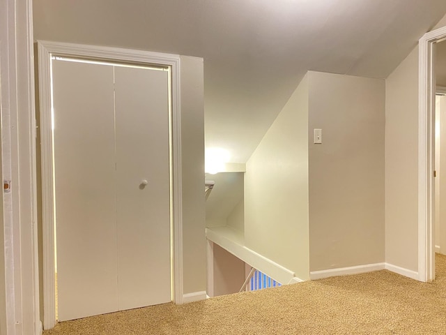 hallway featuring carpet and vaulted ceiling