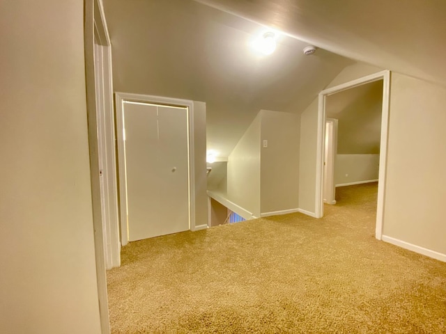 hall with light carpet and vaulted ceiling