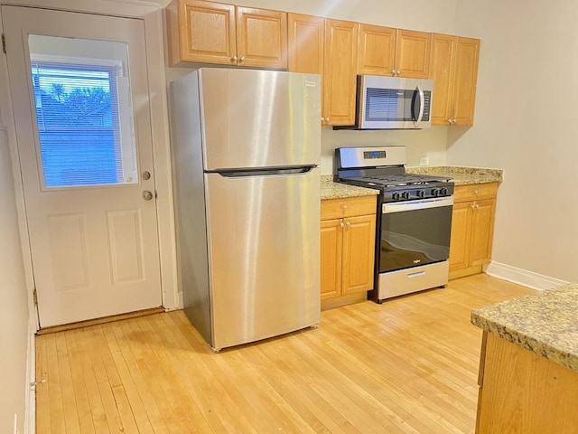 kitchen with light hardwood / wood-style flooring and appliances with stainless steel finishes