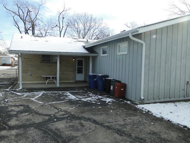 view of snow covered back of property