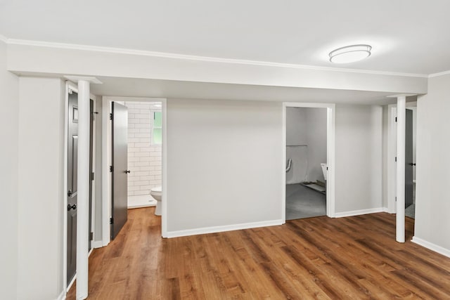 interior space with hardwood / wood-style floors, ensuite bathroom, and ornamental molding