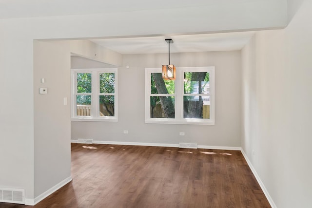 unfurnished dining area featuring dark wood-type flooring