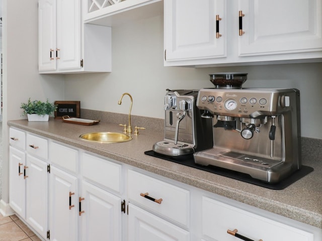 kitchen featuring white cabinets, sink, and light tile patterned flooring