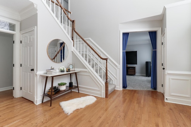 stairway featuring ornamental molding and hardwood / wood-style floors