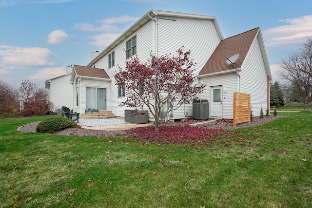 rear view of property featuring central AC, a lawn, and a patio area