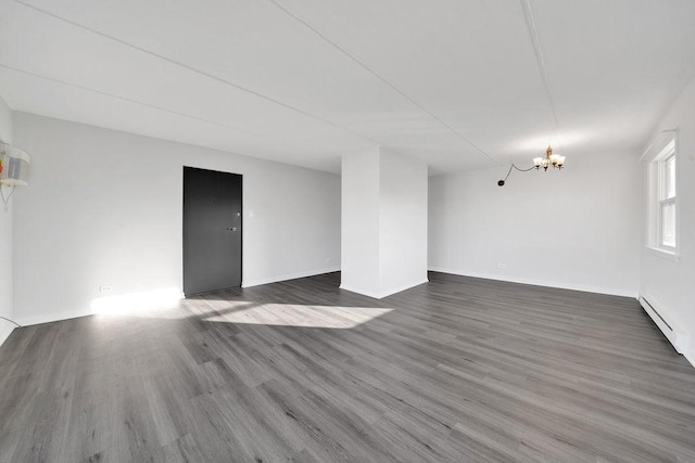 unfurnished room featuring a notable chandelier and dark wood-type flooring