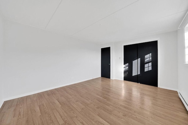 entrance foyer with a baseboard radiator and light wood-type flooring