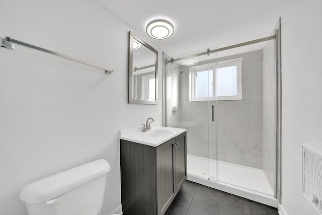 bathroom with tile patterned flooring, vanity, toilet, and walk in shower