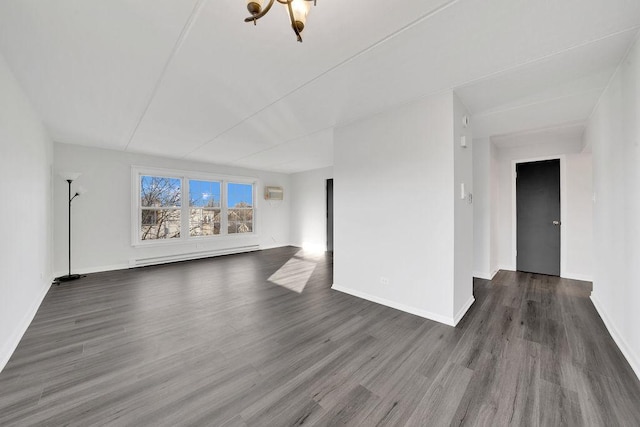 unfurnished living room featuring a wall mounted AC, dark wood-type flooring, a notable chandelier, and a baseboard heating unit