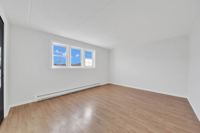 unfurnished room featuring light hardwood / wood-style flooring and a baseboard heating unit