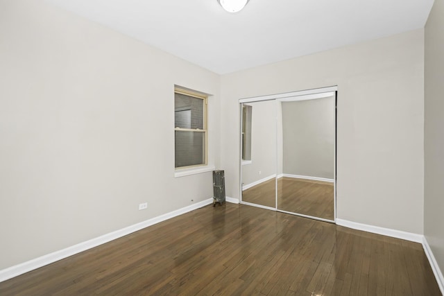 unfurnished bedroom with a closet and dark wood-type flooring