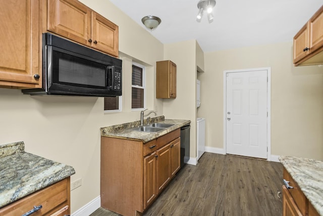 kitchen with dark hardwood / wood-style flooring, light stone counters, sink, and black appliances