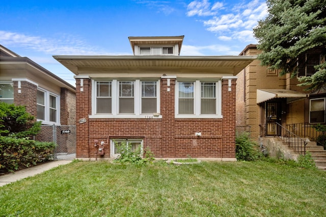 rear view of property featuring a lawn