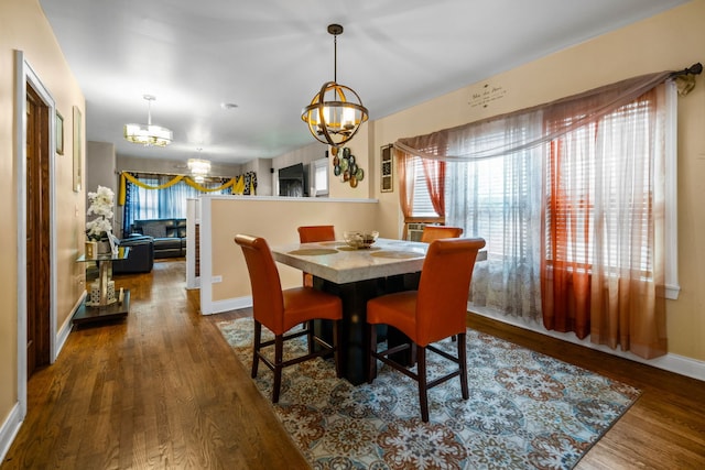 dining room featuring dark hardwood / wood-style flooring and an inviting chandelier