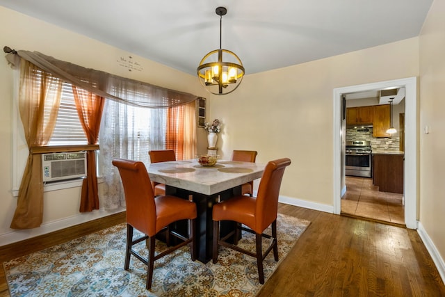 dining room with cooling unit, dark wood-type flooring, and a notable chandelier