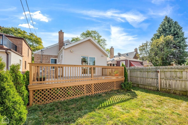 back of property featuring a deck and a lawn